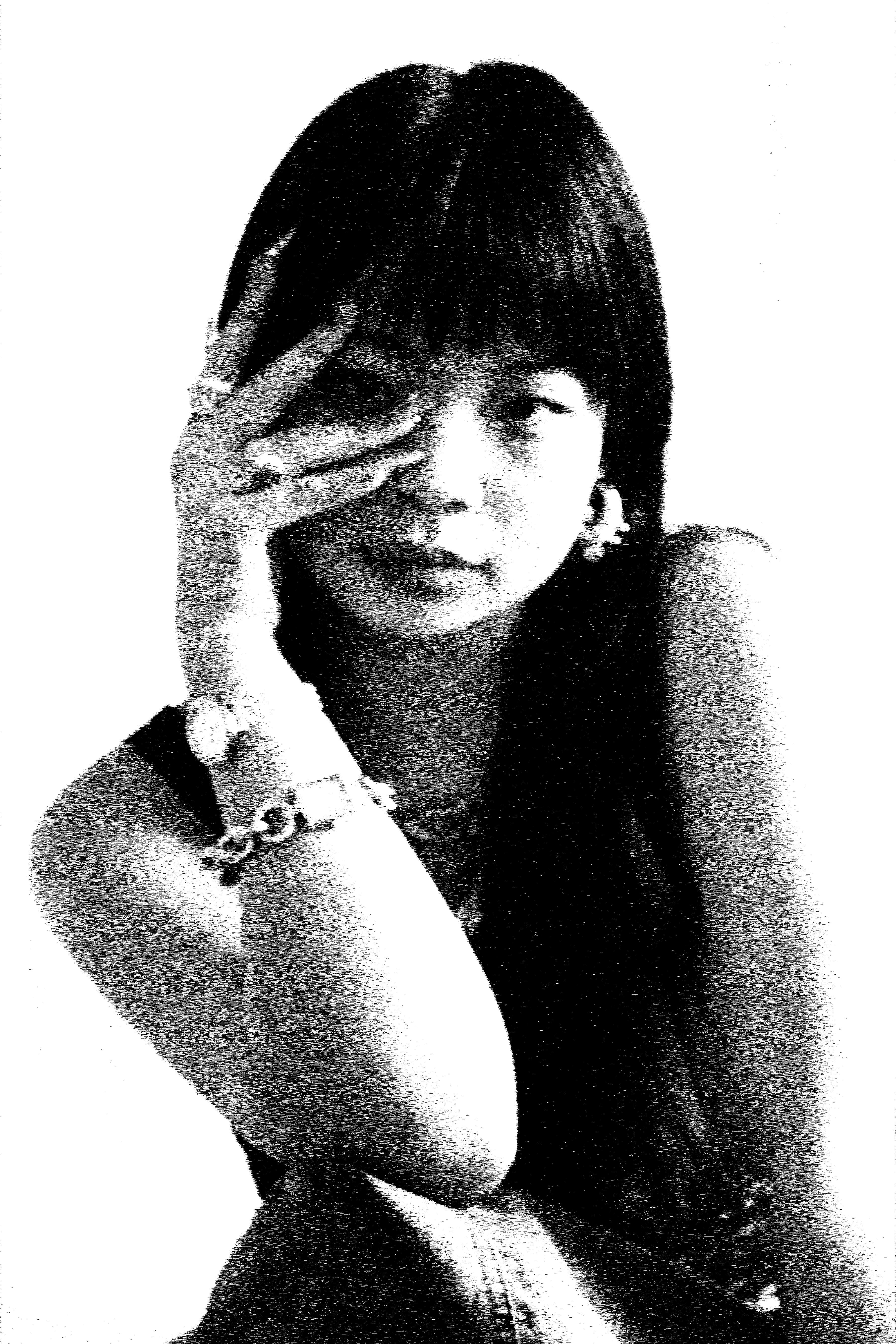 A model shields one eye with an outstretched hand, wearing a chain-link bracelet.